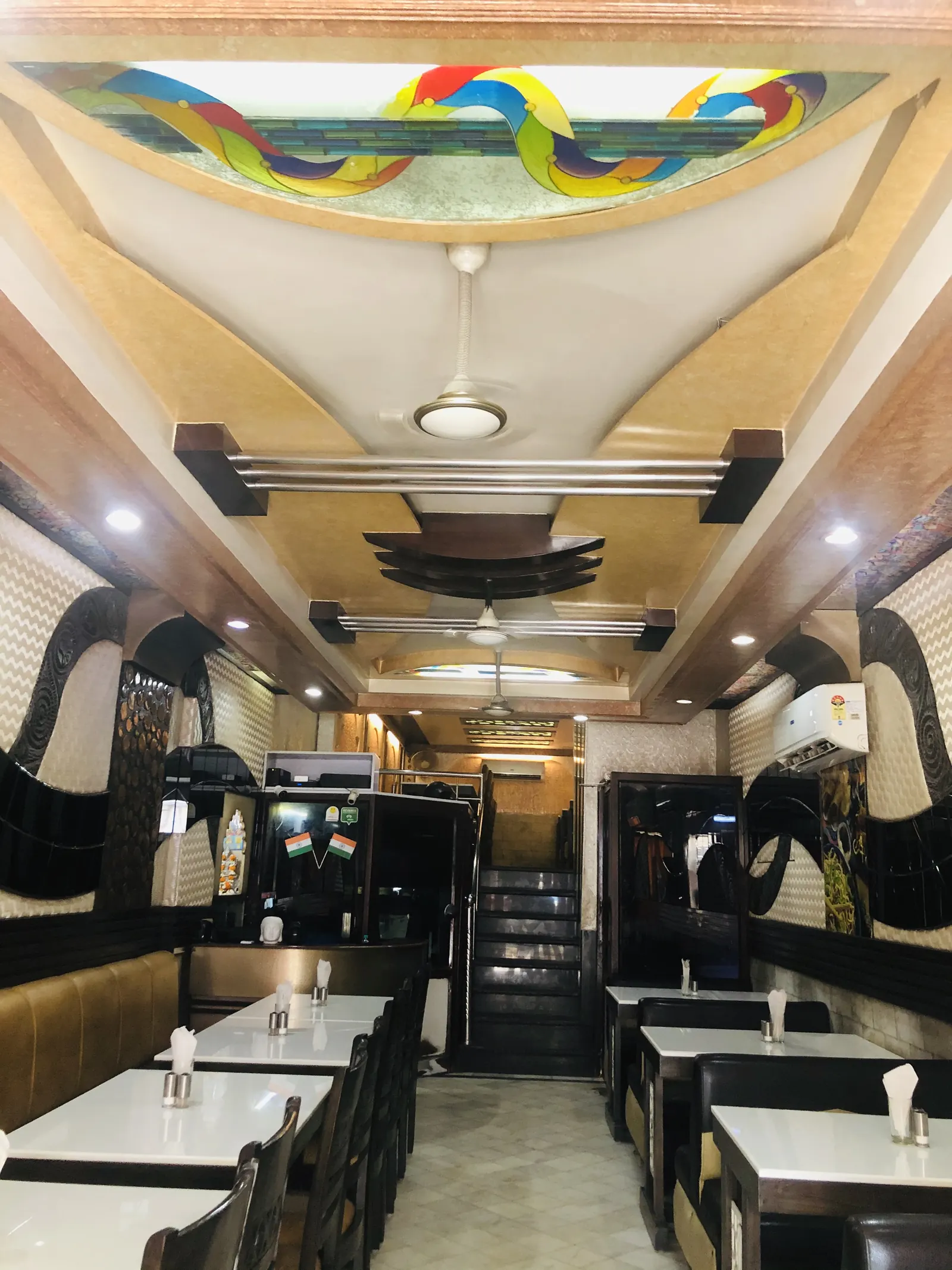 Ground floor dining hall at Chotiwala with tables on both sides